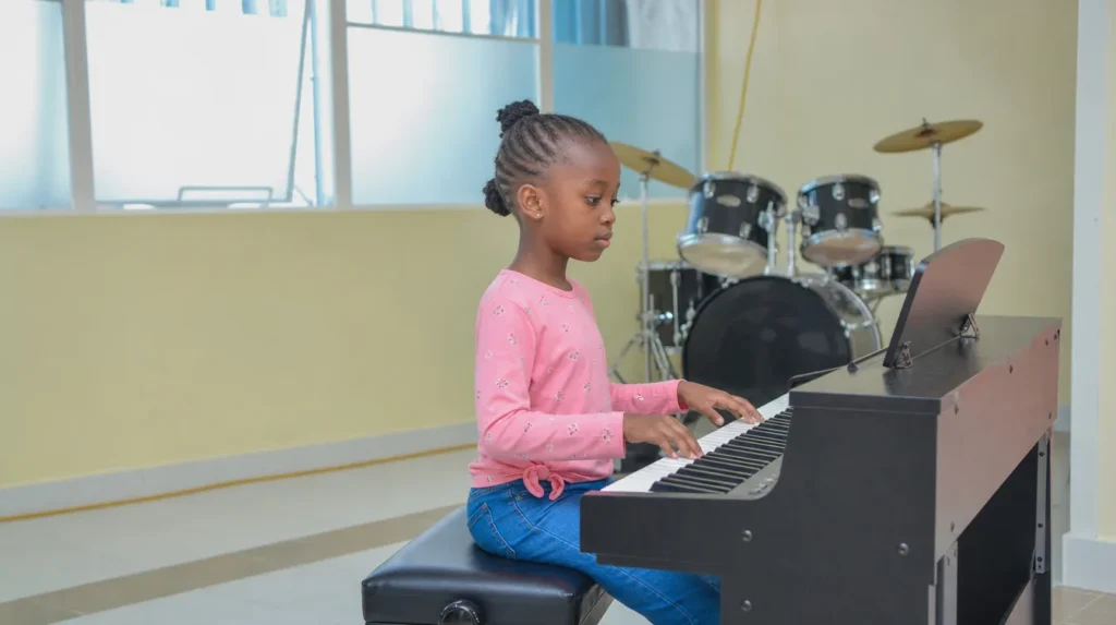 A learner playing the piano in the music room
